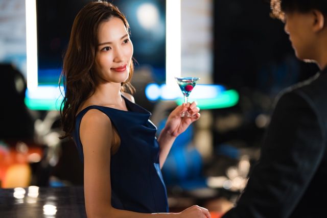 お酒を持って男性と話す女性